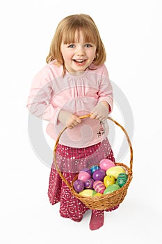 Young Girl Carrying Basket Filled With Easter Eggs