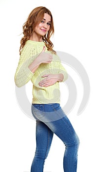 Young girl casual dressed jeans and a green sweater posing in studio show best gesture on white background
