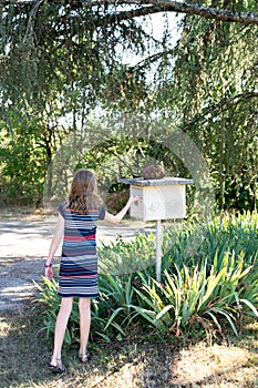 Young girl checking the post box