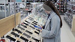 A young girl chooses a smartphone in a store, mall, shopping