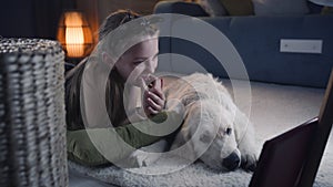 Young girl chosing movie to watch with dog