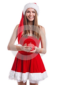 Young girl in Christmas dress and hat , holds a round red candle in her hands. Isolated on white background.