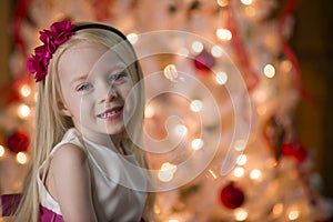 Young girl By Christmas tree lights
