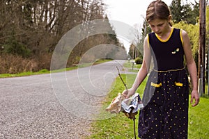 Young Girl Cleaning Up Roadside Environment