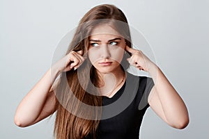 Young girl closes her ears because of loud noise