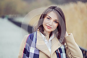 Young girl in coat thinking looking at camera