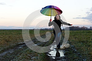 Young emotional woman with an umbrella on a walk, nature light