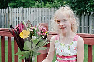 Young Girl in Colorful Dress Smelling Bouquet of Flowers in Springtime