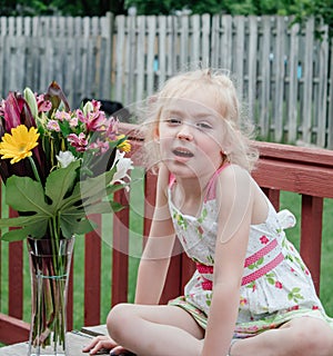 Young Girl in Colorful Dress Smelling Bouquet of Flowers in Springtime