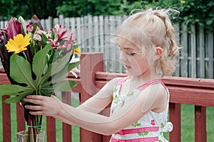 Young Girl in Colorful Dress Smelling Bouquet of Flowers in Springtime