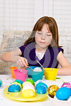 Young girl coloring Easter Eggs