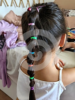 Young girl with colourful braided hair from behind