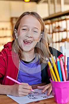 Young girl colouring, smiling