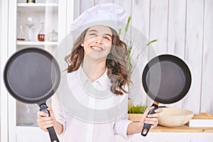 Young girl cooking kitchen. Curly pretty child portrait. Chef christmas student