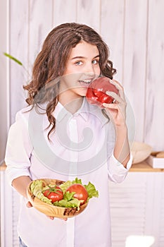 Young girl cooking at kitchen with vegetables. pretty child portrait. Chef