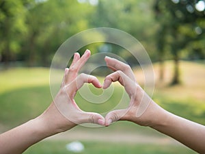 Young girl couple making heart shape with hands, love and relationships concept