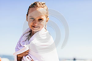 Young girl covered in towel after having a sea bath