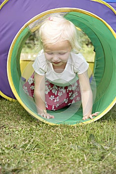 Young Girl Crawling Through Play Equipment