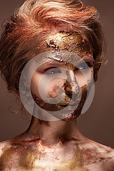 Young girl with creative makeup and textures on her face. Beautiful model with raspberry arrows and golden pigment