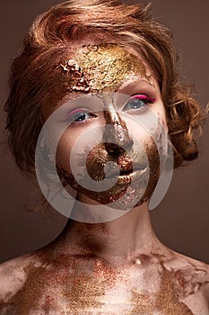 Young girl with creative makeup and textures on her face. Beautiful model with raspberry arrows and golden pigment