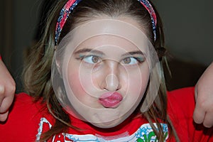 A Young Girl Cross-eyed Puckered Lips Wearing Make-up photo