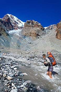 Young girl crossing mountain river