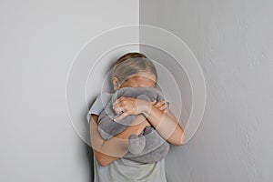 Young Girl Crying with Hands and Toy Covering Face at home