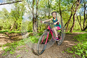 Young girl cycling mountain bike on forest trail