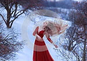 A young girl dances in the wind, her hair is beautifully fluttering. The pose is light and airy, a sense of freedom