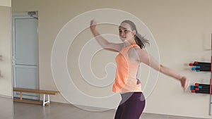 Young girl dancing zumba in gym or studio. Slow motion. Fitness, sport, dance and lifestyle concept