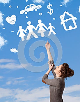 Young girl daydreaming with family and household clouds