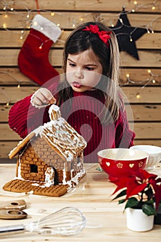 Young girl decorating gingerbread house