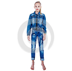 Young girl in a denim suit stands barefoot on a white background