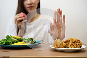 Young girl on dieting for good health concept. Close up female using hand reject junk food by pushing out her favorite fried