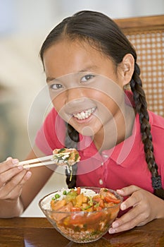 Young girl in dining room eating chinese food