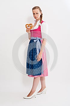 Young girl in Dirndl with pretzel in his hand