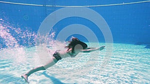 Young girl dive in swimming pool