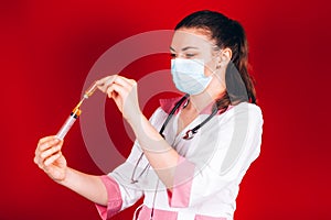 Young girl doctor with a syringe in hand