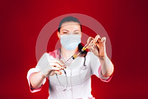 Young girl doctor with a syringe in hand