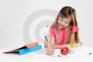 Young girl does her homework on table