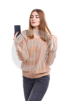 A young girl does selfie on the phone on a white background