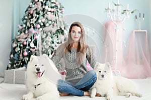 A young girl with a dog near the Christmas tree