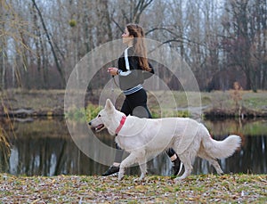 Young girl with dog running at the forest