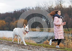 Young girl with dog running at the forest