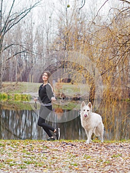 Young girl with dog running at the forest