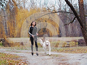 Young girl with dog running at the forest