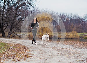 Young girl with dog running at the forest