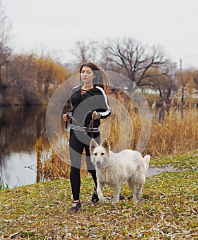 Young girl with dog running at the forest