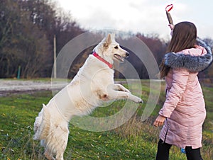 Young girl with dog running at the forest