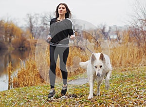 Young girl with dog running at the forest